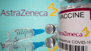 Vial labelled "AstraZeneca COVID-19 Coronavirus Vaccine" and a broken syringe are seen in front of a displayed AstraZeneca logo in this illustration taken March 15, 2021. REUTERS/Dado Ruvic/Illustration