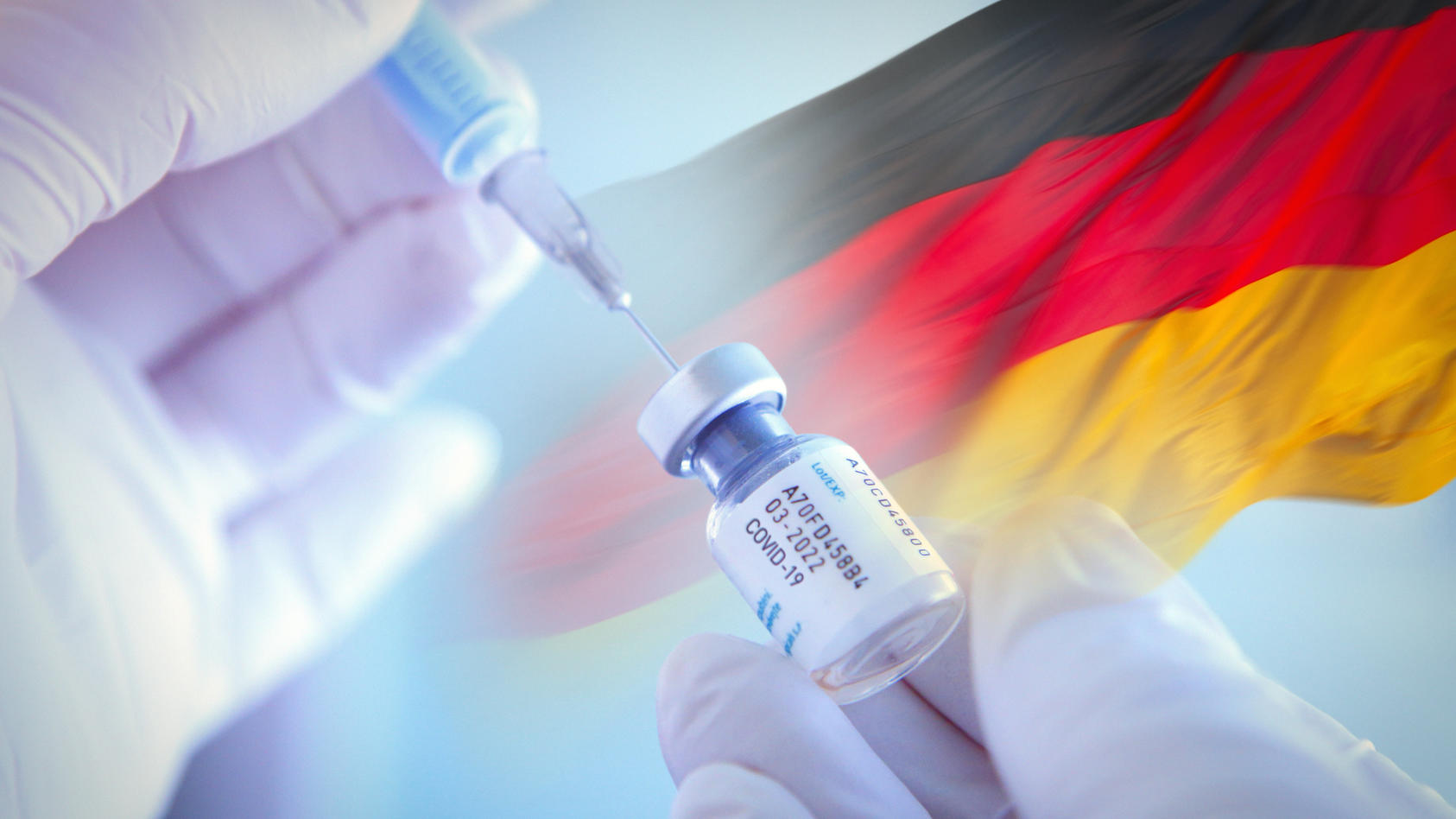Arzt mit Corona-Impfspritze vor Deutschlandfahne