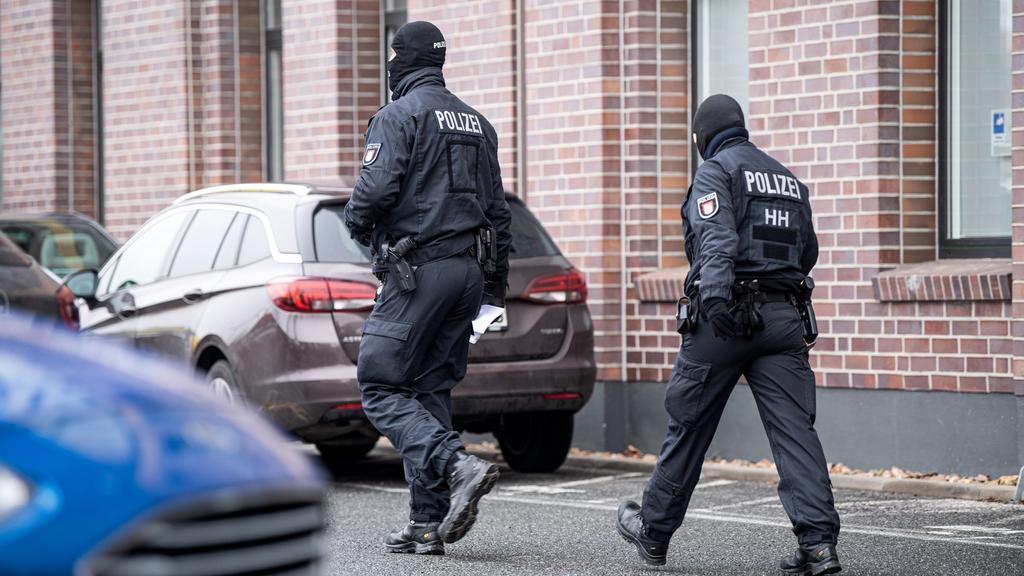 18.03.2021, Bremen: Polizisten gehen vor einem Gebäude im Stadtteil Hemelingen. Bei einem Großeinsatz im kriminellen Milieu in Bremen sind einem Medienbericht zufolge vier Menschen festgenommen worden. Hintergrund sei ein Ermittlungskomplex der Staat