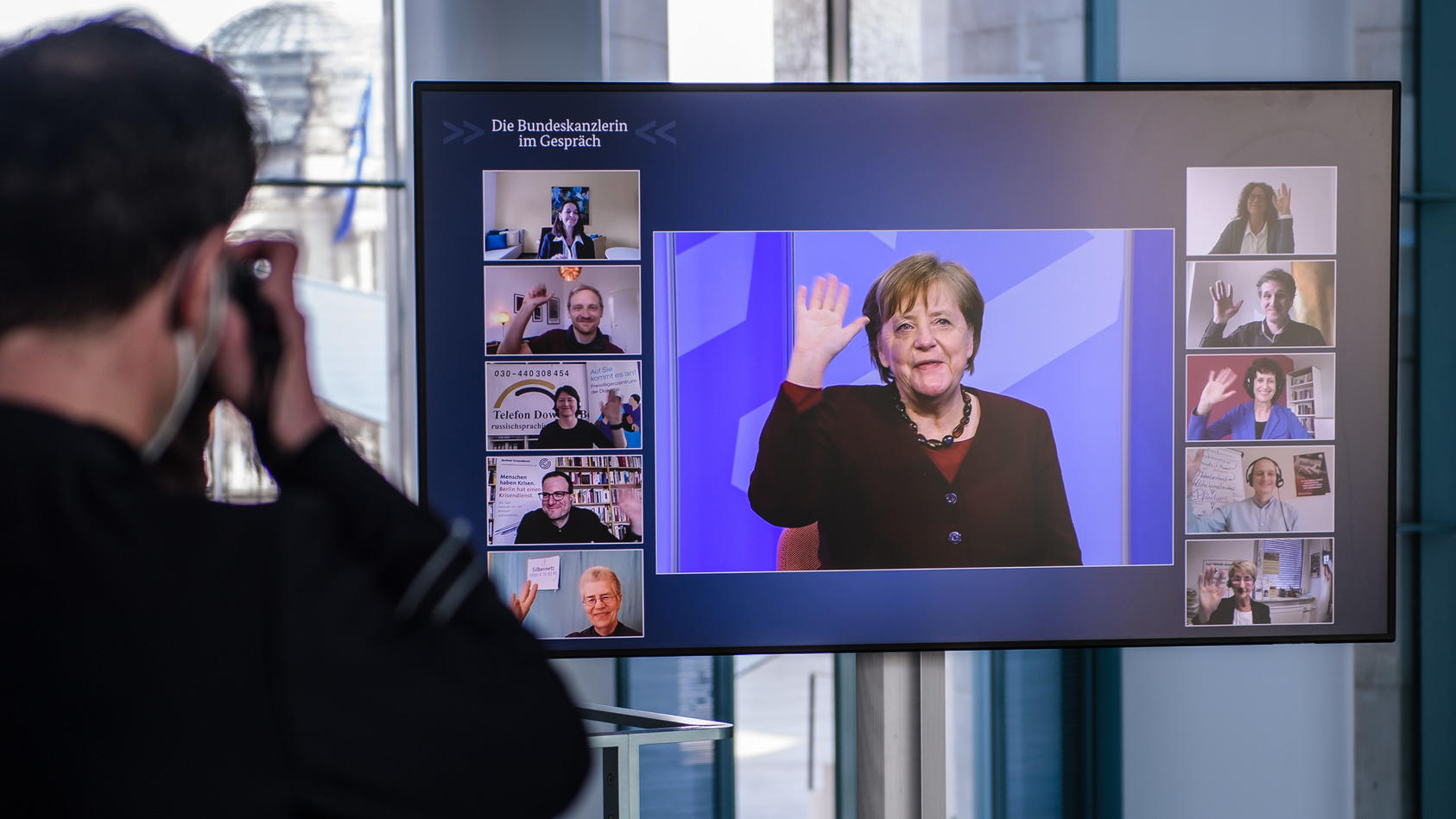 10.03.2021, Berlin: Bundeskanzlerin Angela Merkel winkt, als sie während einer Videokonferenz der digitalen Dialogreihe "Die Bundeskanzlerin im Gespräch" auf einem Bildschirm im Kanzleramt zu sehen ist. In der Dialogreihe "Die Bundeskanzlerin im Gesp