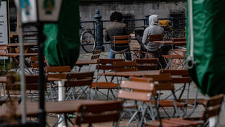 18.03.2021, Berlin: Zwei Männer sitzen auf Stühlen einer geschlossenen Außengastronomie im Nikolaiviertel. Aufgrund der Corona-Pandemie sind derartige Betriebe bis auf weiteres geschlossen. Foto: Paul Zinken/dpa-Zentralbild/dpa +++ dpa-Bildfunk +++