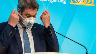 16.03.2021, Bayern, München: Markus Söder (CSU), Ministerpräsident von Bayern, setzt sich nach der Sitzung des bayerischen Kabinetts während einer abschließenden Pressekonferenz seine FFP2 Maske auf. Foto: Peter Kneffel/dpa +++ dpa-Bildfunk +++