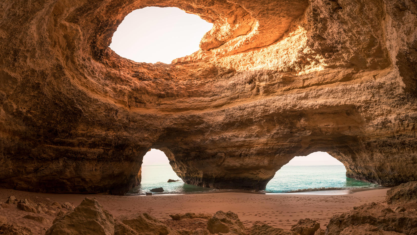 Spacious stone cave with holes in the ceiling near sea on sunny day in Benagil Caves in Algarve, Portugal Copyright: xFranciscoxCarrodeguasx