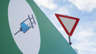 26.02.2021, Niedersachsen, Hannover: Ein Schild mit einer Spritze hängt an der Zufahrt zum Impfzentrum auf dem Messegelände. Foto: Julian Stratenschulte/dpa +++ dpa-Bildfunk +++