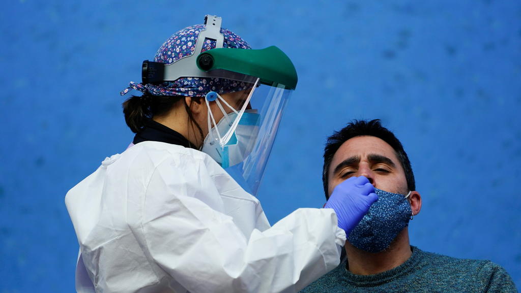 A nurse conducts a PCR (polymerase chain reaction) swab test on a resident of the Basque town of Elorrio during mass testing, following an upsurge of coronavirus disease (COVID-19) cases in the municipality, in Elorrio, Spain March 23, 2021. REUTERS