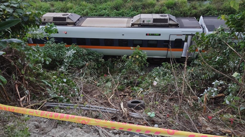 A section of a derailed train is seen cordoned off near the Toroko Gorge area in Hualien, Taiwan on Friday, April 2, 2021. The train partially derailed in eastern Taiwan on Friday after colliding with an unmanned vehicle that had rolled down a hill, 
