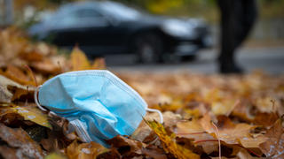 ARCHIV - 19.10.2020, Baden-Württemberg, Bad Urach: Eine Gesichtsmaske liegt am Straßennrand im Herbstlaub. (zu dpa: «Falsche Entsorgung von Masken - Corona verändert Müllaufkommen») Foto: Sebastian Gollnow/dpa +++ dpa-Bildfunk +++