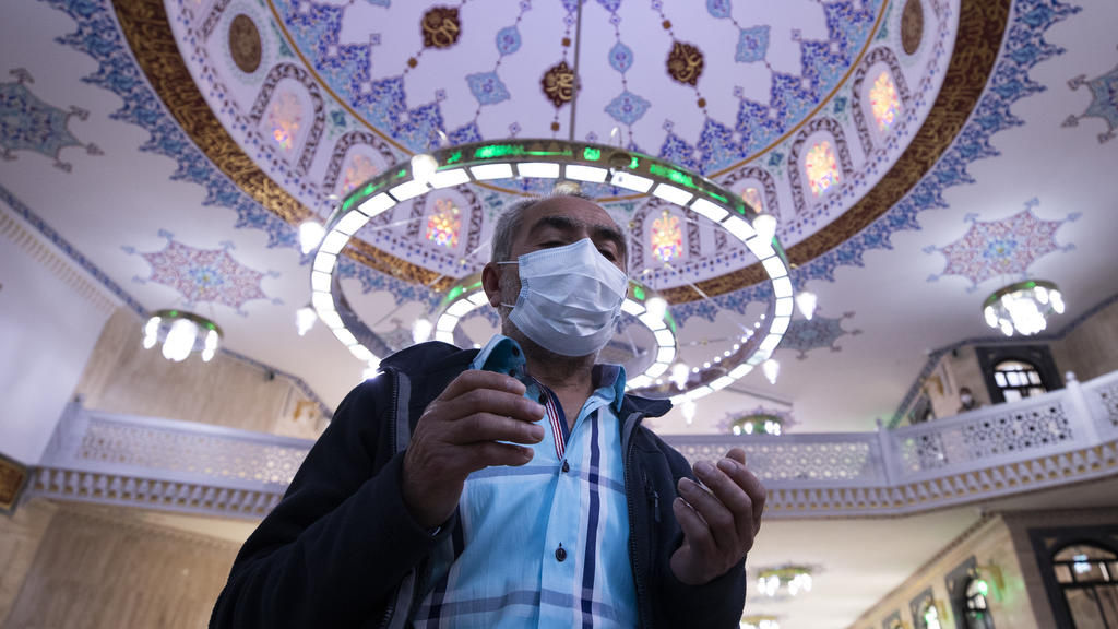 Mann mit Corona-Maske betet in einer Moschee in Berlin