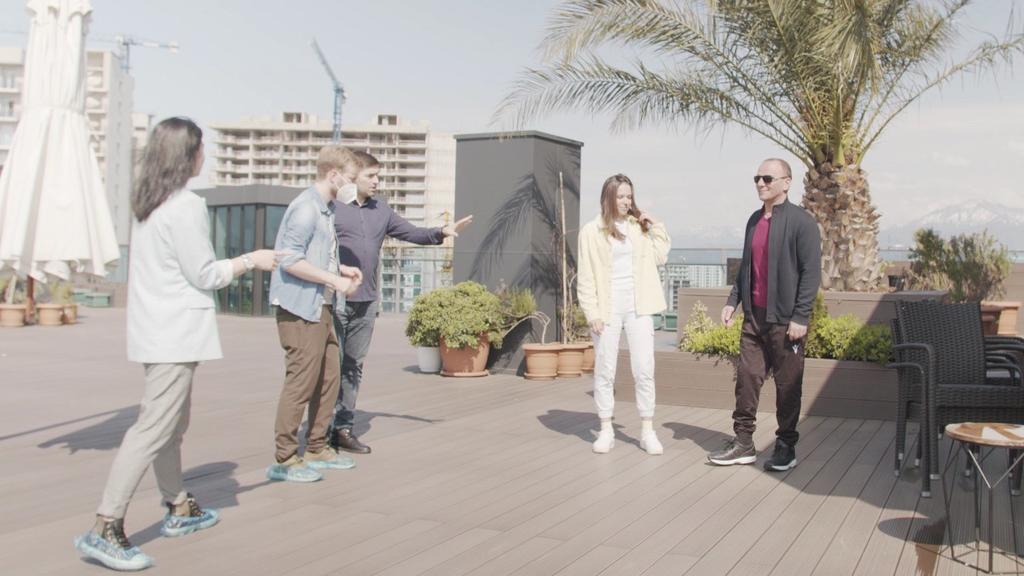 Christina, Galip und Dominique machen ein Foto auf der Dachterrasse des Hochhauses.
