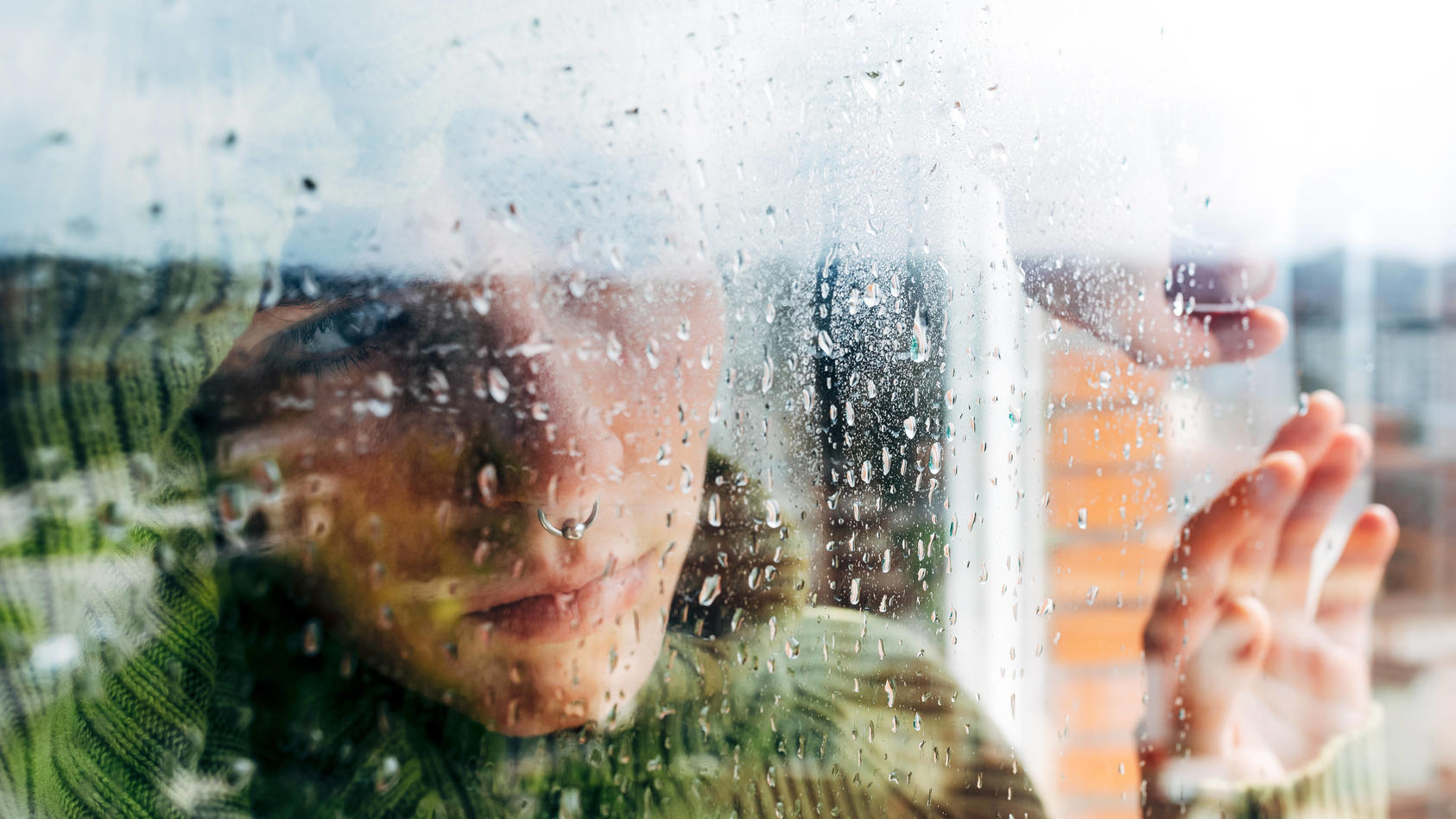 Melancholic young woman looking through window Copyright: xAlbertoxMenendezx