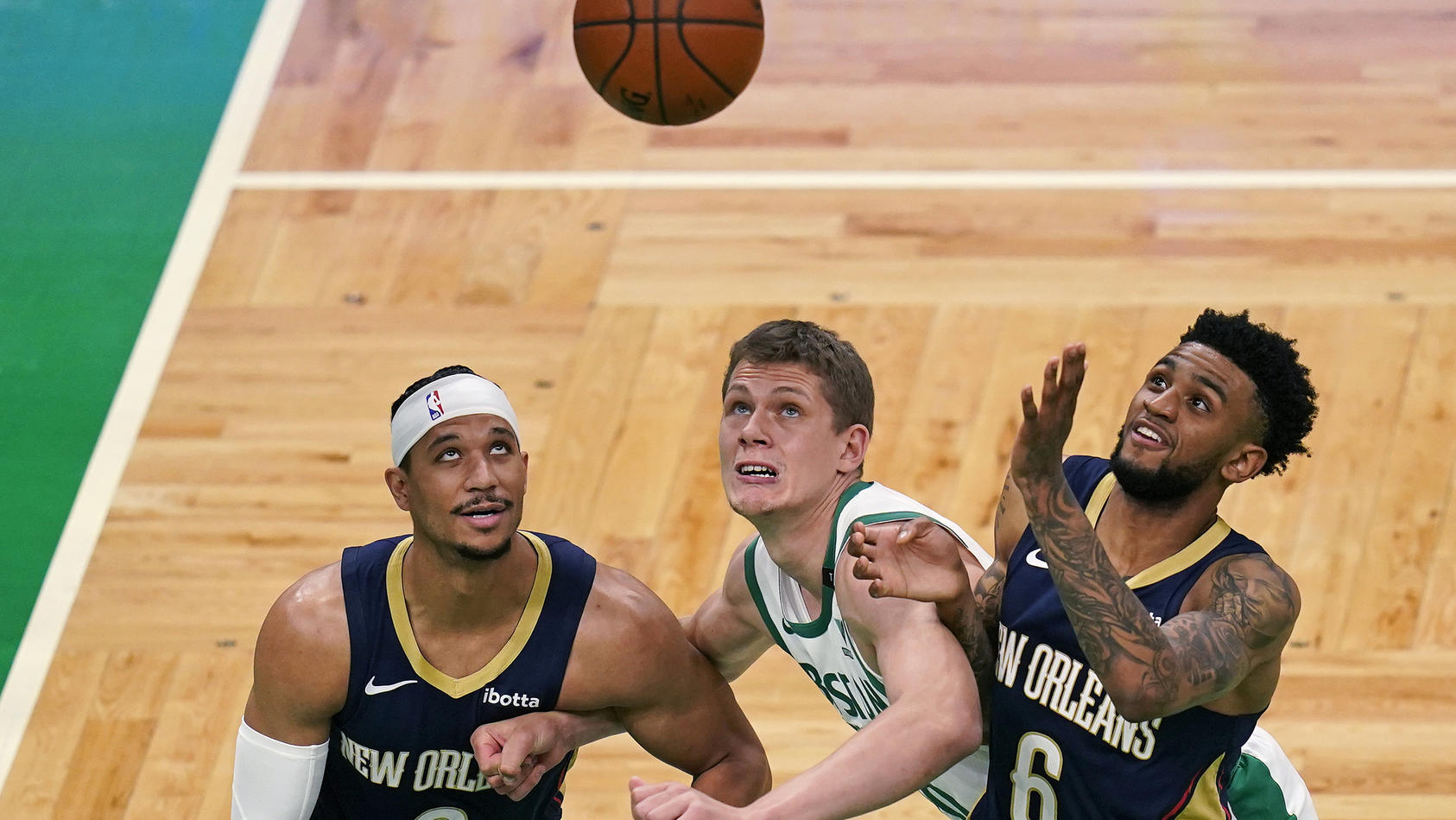 Boston Celtics forward Moritz Wagner, center, is boxed out by New Orleans Pelicans' Josh Hart, left, and Nickeil Alexander-Walker, right, during the first half of an NBA basketball game, Monday, March 29, 2021, in Boston. (AP Photo/Charles Krupa)