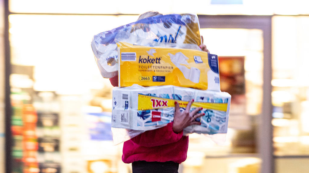 05.11.2020, Hamburg: Ein Frau läuft mit dem Arm voller Klopapierrollen aus einem Drogeriemarkt heraus. Gähnend leere Regale, wo sonst das Toilettenpapier thronte, waren im März dieses Jahres keine Seltenheit in deutschen Supermärkten. Weil viele der