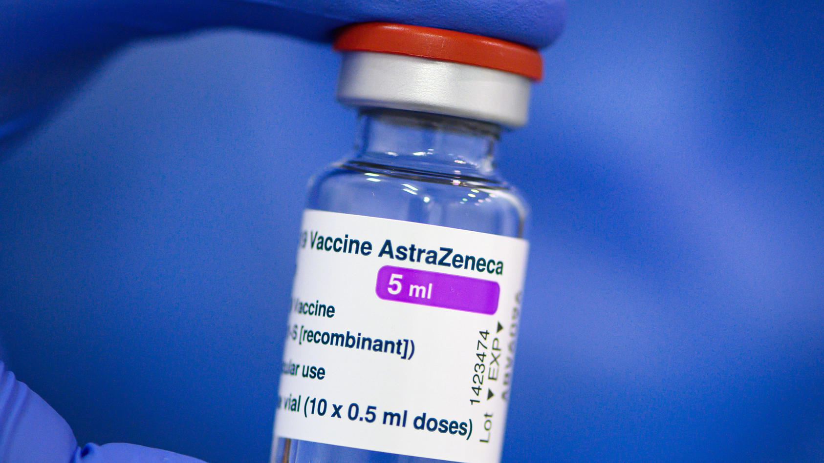 Ein Mitarbeiter im Impfzentrum in der Messe Dresden hält ein Fläschchen mit dem Astrazeneca-Wirkstoff gegen Corona in seiner Hand.