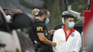 A Houston Police officer takes into a custody a man who was found inside the house where more than 90 undocumented migrants were found on the 12200 block of Chessington Drive on Friday, April 30, 2021, in Houston. A Houston Police officials said the case will be handled by federal authorities. (Godofredo A. VÃ¡squez/Houston Chronicle via AP)