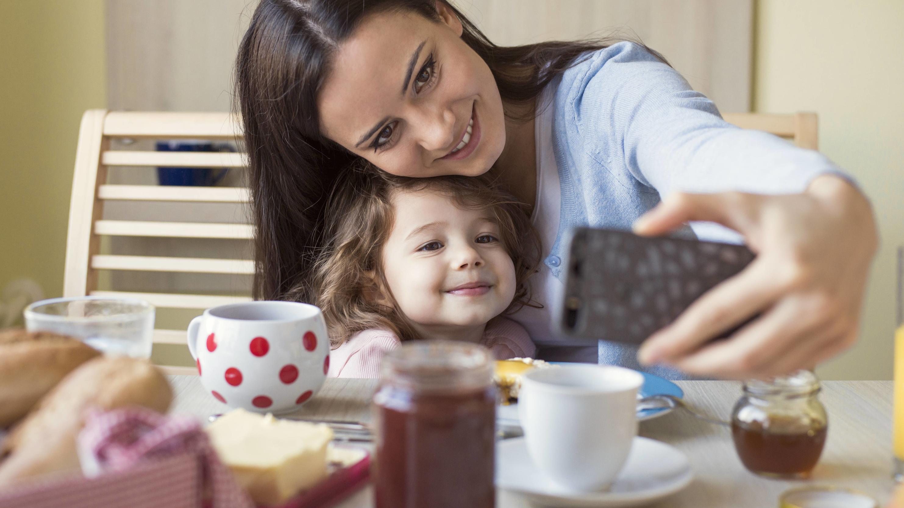 Portrait of mother and her little daughter taking a selfie at breakfast table model released Symbolfoto property released PUBLICATIONxINxGERxSUIxAUTxHUNxONLY HAPF000125Portrait of Mother and her Little Daughter Taking a Selfie AT Breakfast Table Mode