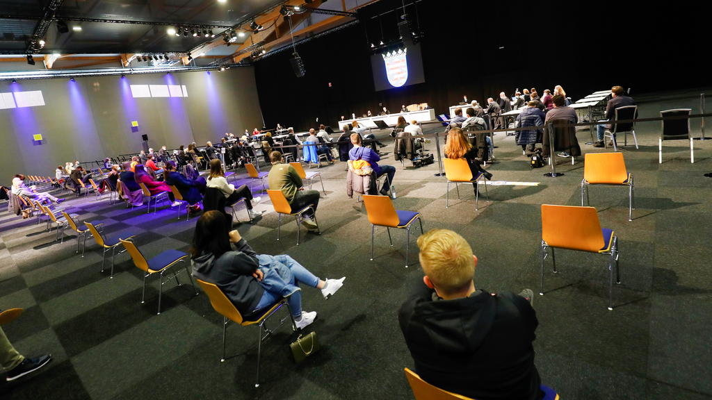 People sit inside the hall on the fairground of Messe Kassel, converted into a court room, on the opening day of the trial against Maurice P., who crashed his car into a carnival parade injuring several people in Volkmarsen on February 25, 2020, in K