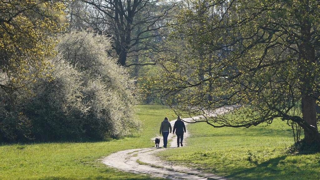 03.05.2021, Hamburg: Passanten gehen mit einem Hund im Jenischpark spazieren. Foto: Marcus Brandt/dpa +++ dpa-Bildfunk +++