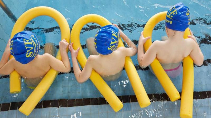Kinder sitzen beim Schwimmunterricht im Wasser. Foto: Georg Wendt/dpa/Archivbild