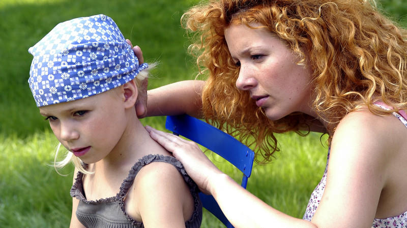 Eine Mutter sucht auf der Haut ihrer kleinen Tochter nach Zecken, aufgenommen 2005. Foto: Chiron Vaccines +++(c) dpa - Report+++