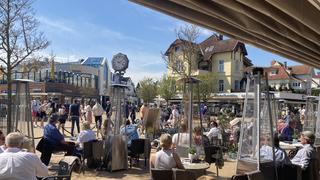 09.05.2021, Schleswig-Holstein, Timmendorfer Strand: Zahlreiche Gäste sitzen in einem Cafe an der Lübecker Bucht. Seit Samstag, 8. Mai 2021 sind die Tourismusangebote in der inneren Lübecker Bucht wieder für Gäste geöffnet. Die innere Lübecker Bucht ist die dritte von vier touristischen Modellregionen Schleswig-Holsteins, in denen wieder Restaurantbesuche und touristische Übernachtungen möglich sind. Dabei gelten strenge Hygieneauflagen. Foto: Thomas Müller/dpa +++ dpa-Bildfunk +++