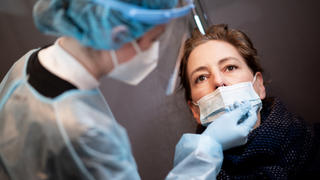 11.04.2021, Hamburg: Eine Frau lässt sich in einem Corona-Schnelltest-Zentrum mit einem Nasenabstrich auf das Coronavirus testen. Foto: Daniel Reinhardt/dpa +++ dpa-Bildfunk +++