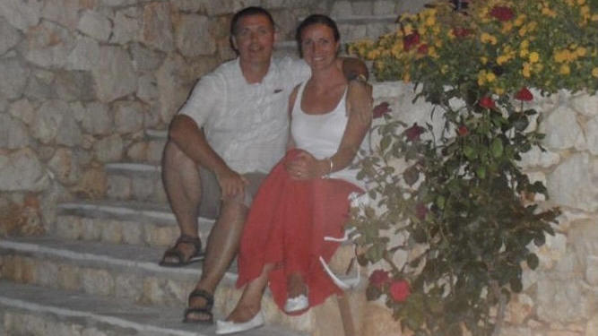 Caroline und ihr Mann Roy sitzen zusammen auf einer Treppe.