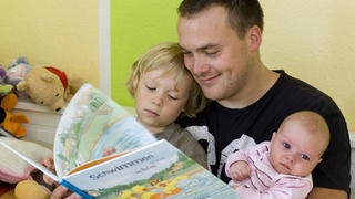 ARCHIV - 17.07.2008, Brandenburg, Frankfurt:oder: Andreas Lange liest seinem Sohn Janne und seiner Totcher Fiona vor. Der Vater hat drei Monate Elternzeit genommen. Väter, die in Elternzeit gehen, verbringen mehr Zeit mit ihren Kindern und machen mehr im Haushalt. Dieser Effekt hält auch noch Jahre nach dem Ende der Pause an, wie eine Studie des RWI-Leibniz-Instituts für Wirtschaftsforschung in Essen zeigt. Foto: Patrick Pleul/dpa-Zentralbild/dpa +++ dpa-Bildfunk +++