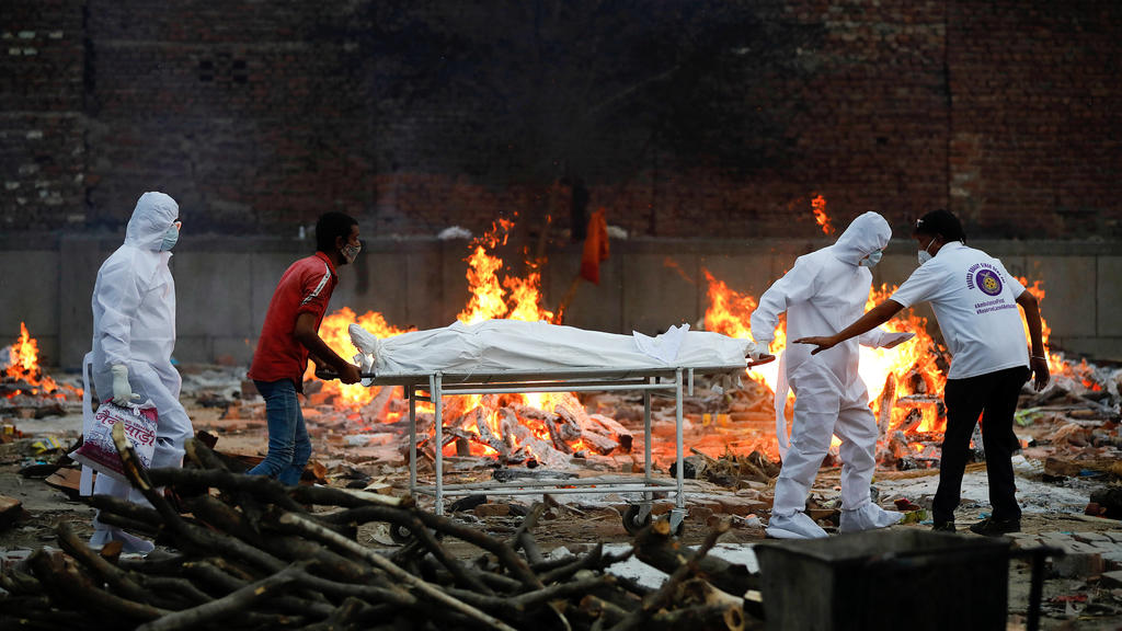 May 9, 2021, Delhi, India: Relatives and health workers carry a body of coronavirus Covid-19 victim during a cremation at a crematorium in New Delhi..India reports 3,66,161 new cases, 3,754 deaths in the last 24 hours. Delhi India - ZUMAs197 20210509