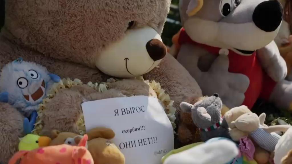Kuscheltiere und Blumen vor der Schule
