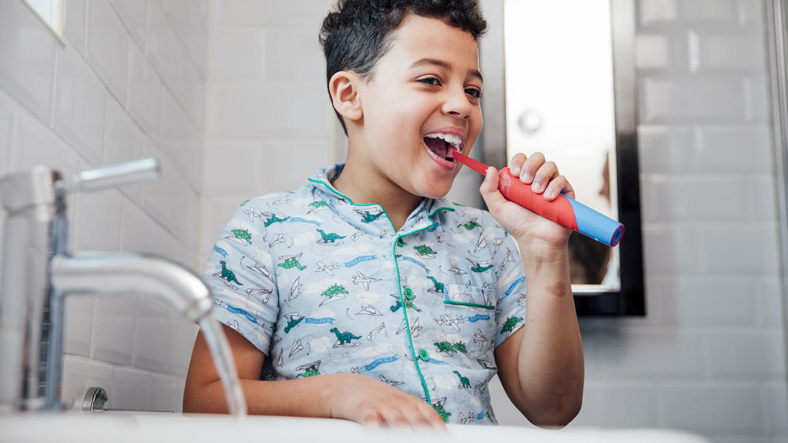 Junge benutzt elektrische Zahnbürste für Kinder