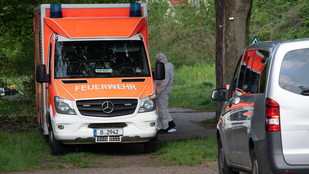 15.05.2021, Berlin: Ein Kriminaltechniker der Polizei steht an einem Rettungswagen unweit einer Parkanlage an der Idsteiner Straße Ecke Seibtweg in Berlin-Zehlendorf . Dort wurde am frühen Morgen ein schwer verletzter Mann gefunden. Bei einem Streit