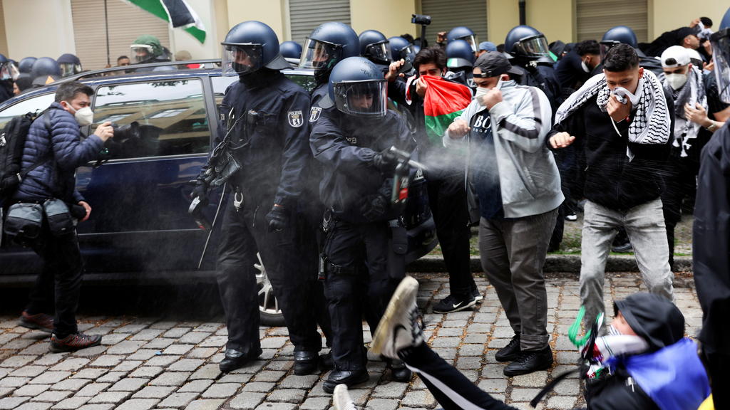 A police officer uses a pepper spray against a man during a demonstration to mark the Nakba and in support of Palestinians, in Berlin, Germany May 15, 2021. REUTERS/Christian Mang
