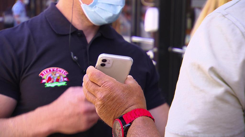 Gast zeigt Handy bei Einlass vor