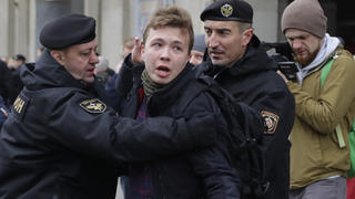 FILE - In this Sunday, March 26, 2017 file photo, Belarus police detain journalist Raman Pratasevich, center, in Minsk, Belarus. Raman Pratasevich, a founder of a messaging app channel that has been a key information conduit for opponents of Belarusâ€™ authoritarian president, has been arrested after an airliner in which he was riding was diverted to Belarus because of a bomb threat. The presidential press service said President Alexander Lukashenko personally ordered that a MiG-29 fighter jet accompany the Ryanair plane â€” traveling from Athens, Greece, to Vilnius, Lithuania â€” to the Minsk airport. ï»¿ï»¿(AP Photo/Sergei Grits, File)