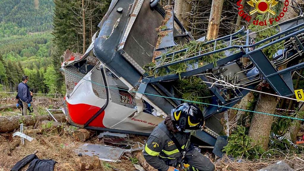 HANDOUT - 23.05.2021, Italien, Stresa: Rettungskräfte arbeiten am Wrack einer abgestürzten Gondel, die in einem Waldstück liegt. Beim Absturz der Gondel einer Seilbahn am norditalienischen Lago Maggiore haben mindestens 14 Menschen ihr Leben verloren