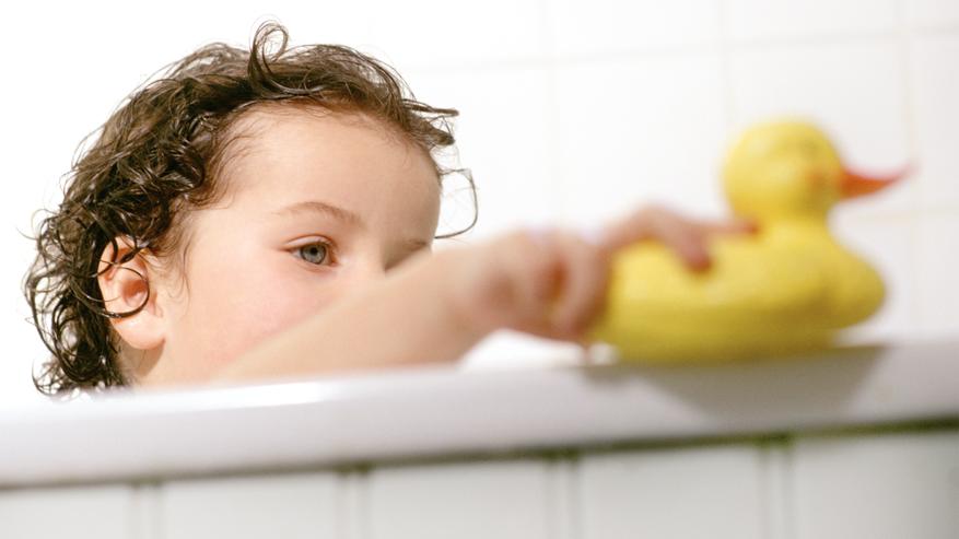 Ein Kind sitzt in der Badewanne.
