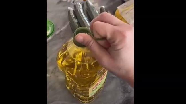Die Lasche an der Ölflasche wird abgemacht