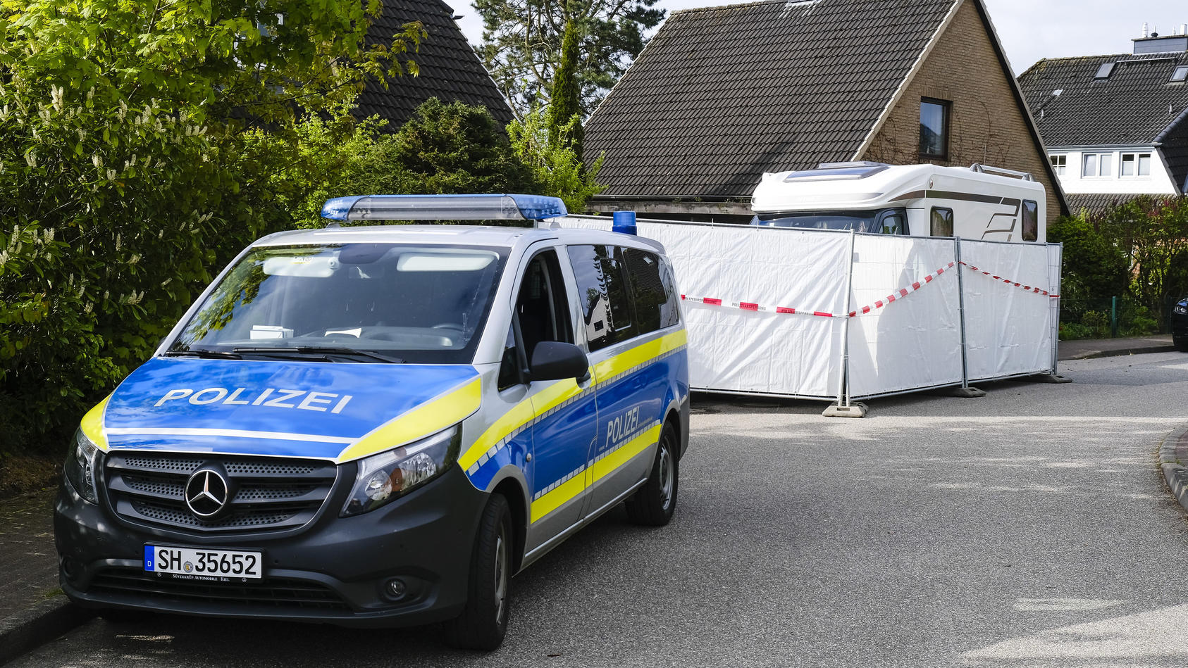 20.05.2021, Schleswig-Holstein, Dänischenhagen: Ein Streifenwagen der Polizei steht am Haus, in dem am 19.05.2021 zwei Tote gefunden wurden. In dem Ort bei Kiel sind in einer Doppelhaushälfte zwei Menschen getötet worden. Foto: Frank Molter/dpa +++ d