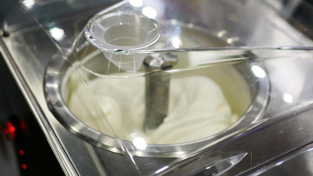 Eine Eismaschine rührt Vanilleeis cremig