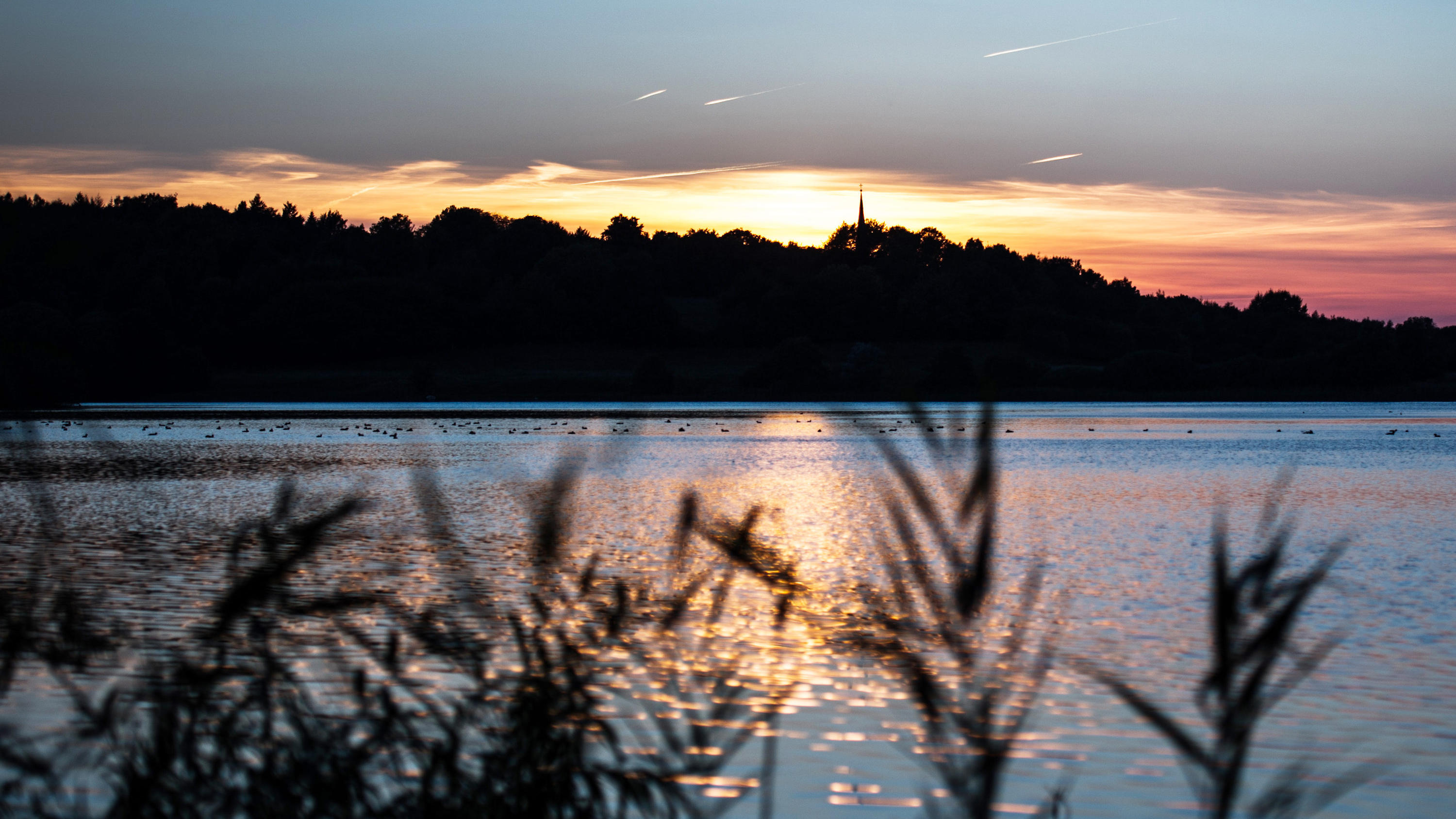 ARCHIV - Die Sonne geht  am 02.10.2013 am kleinen Plöner See in Plön (Schleswig-Holstein) unter. Das Umweltministerium, die Wasser- und Bodenverbände sowie die Gemeinden in Schleswig-Holstein unterzeichneten eine Zielvereinbarungen für den besseren S