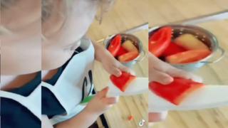 Ein Kleinkind schneidet eine Paprika mit einem großen Messer.