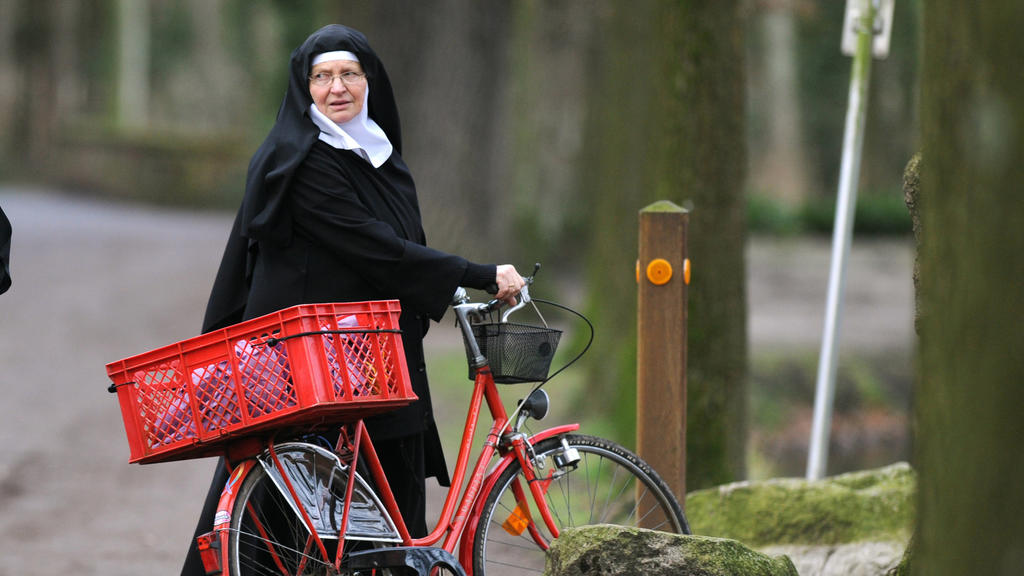 Schwester Victoria fährt in ihrer Ordenskleidung Fahrrad