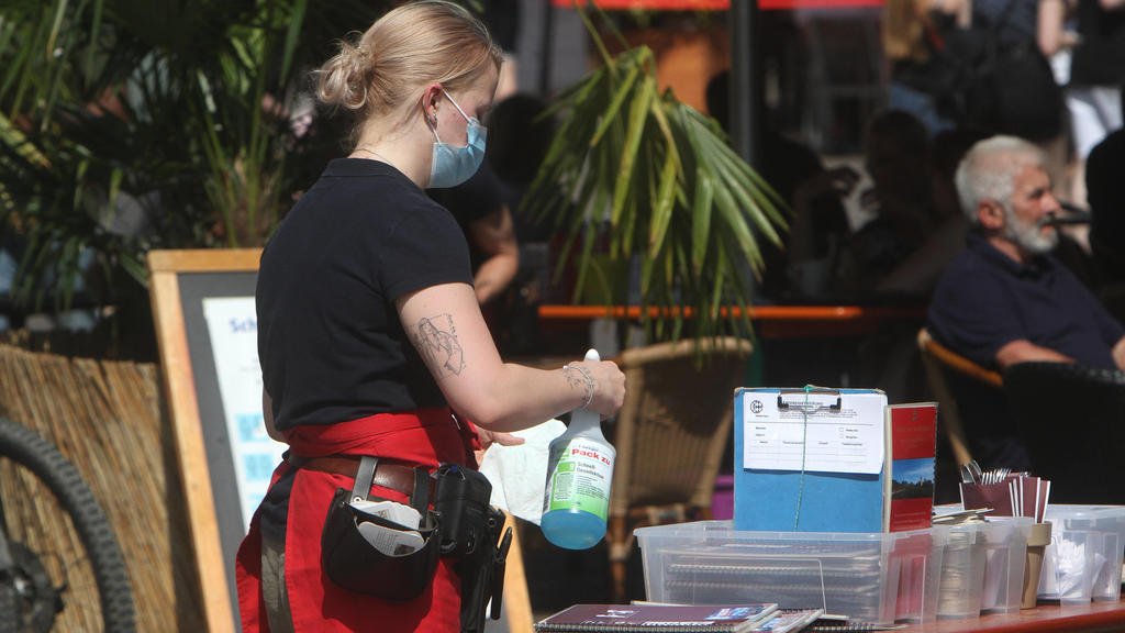 Aufgrund anhaltend niedriger Inzidenzen in Würzburg dürfen gastronomische Betriebe ihren Außenbereich auch ohne negativen Coronatest wieder öffnen. Eine Kellnerin eines Restaurants in der Innenstadt reinigt und desinfiziert Speisekarten am Hygienetis