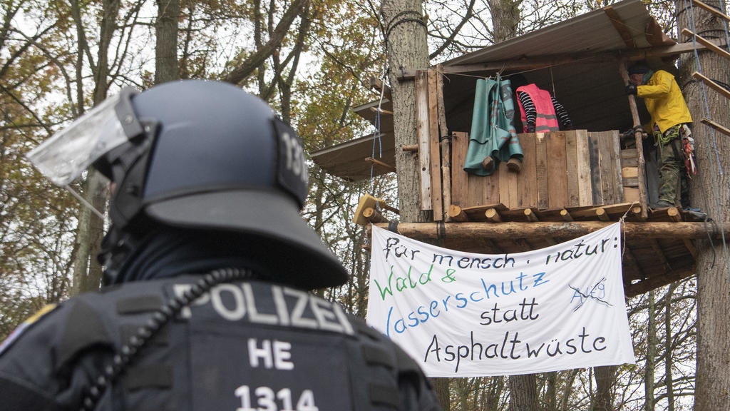 ARCHIV - 10.11.2020, Hessen, Niederklein: Ein Polizist steht im Dannenröder Forst vor einem Baumhaus, in dem sich Aktivisten aufhalten. Die Demonstranten protestierten gegen weitere Rodungsarbeiten für den Weiterbau der Autobahn 49. (zu dpa «Land