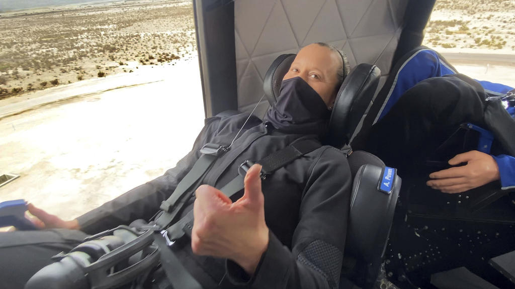 In this photo made available by Blue Origin, Audrey Powers gives a thumbs up inside the New Shepard rocket capsule during a crew rehearsal in West Texas on Wednesday, April 14, 2021. Two employees were strapped into the fueled rocketship for practice