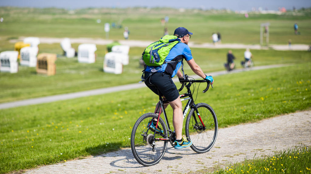 Urlaub in Deutschland Fahrradfahrer machen an der Strandpromenade im Urlaubsort Schillig eine Fahrradtour. Foto: Kirchner-Media/Wedel Schillig Niedersachsen Deutschland *** Vacation in Germany cyclists make a bicycle tour at the beach promenade in th