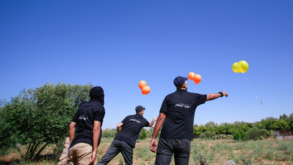 June 15, 2021, Gaza, Palestine: Masked Palestinians launch incendiary balloons from the Gaza Strip towards Israel..Palestinian activists launch incendiary balloons from the Gaza Strip towards Israel in protest to the flag march in East Jerusalem hap