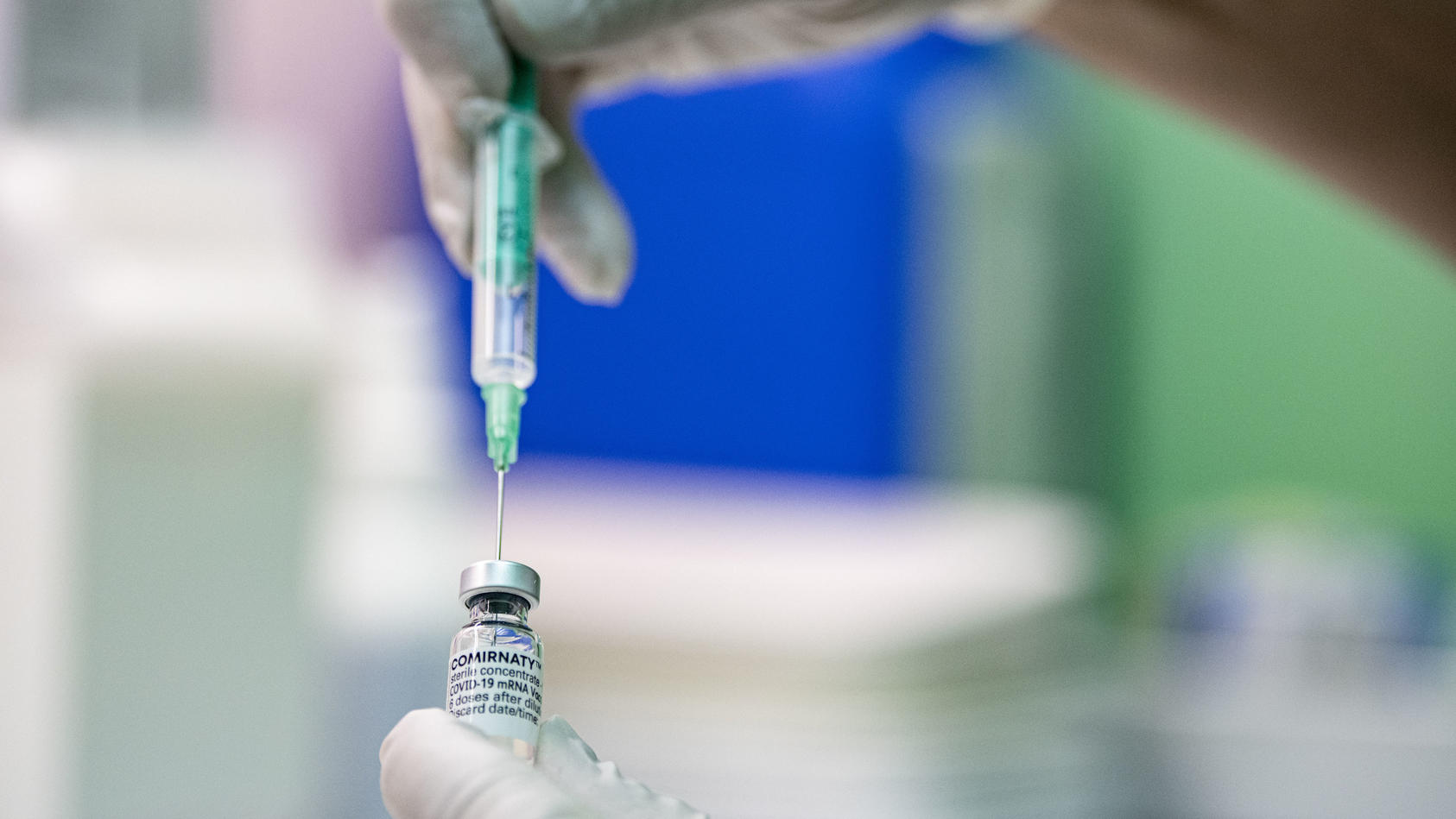 ARCHIV - 09.06.2021, Berlin: Ein Kinder- und Jugendarzt zieht den Corona-Impfstoff Comirnaty von Biontech/Pfizer in eine Spritze. Ein vollständiger Impfschutz mit zwei Dosen der Mittel von Biontech/Pfizer oder Astrazeneca verhindert einer britischen 