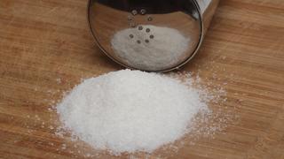 Ein kleiner Haufen Salz vor einem Salzstreuer