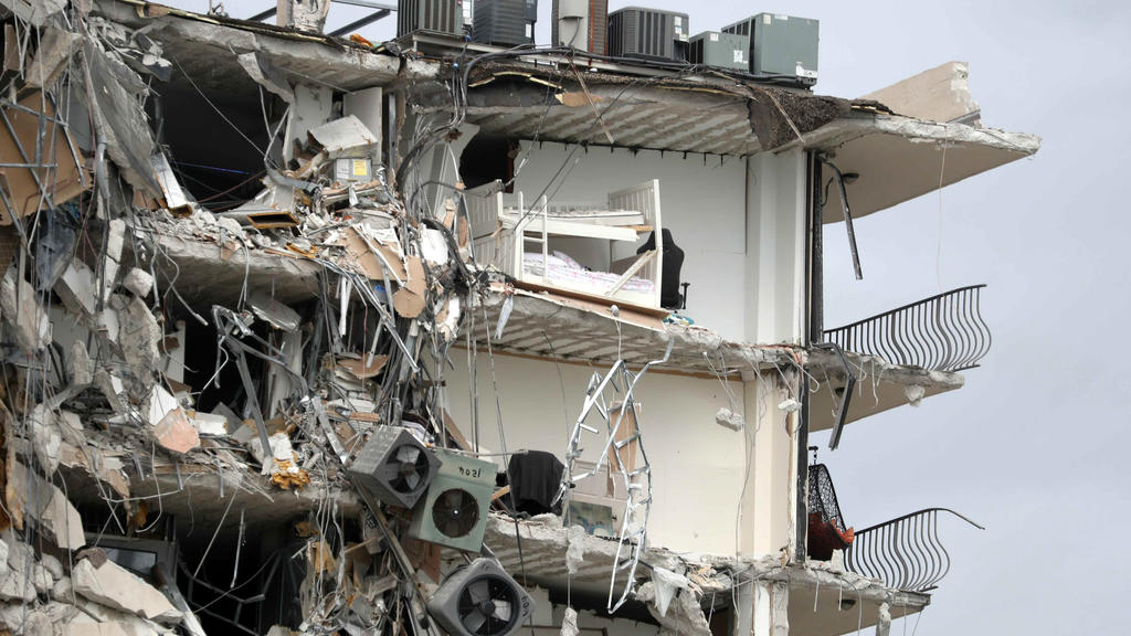 Items and debris dangle from a section of the oceanfront Champlain Towers South Condo that partially collapsed Thursday, June 24, 2021, in the Surfside area of Miami, Fla. (Susan Stocker/South Florida Sun-Sentinel via AP)